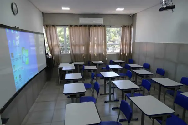Sala de aula com carteiras e projeção na parede