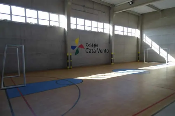 Quadra coberta com logo do colégio na parede