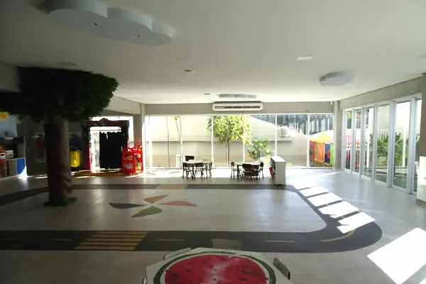 Espaço coberto da Educação Infantil com árvore cenográfica