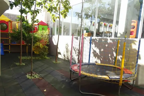 Parque com cama elástica e árvores